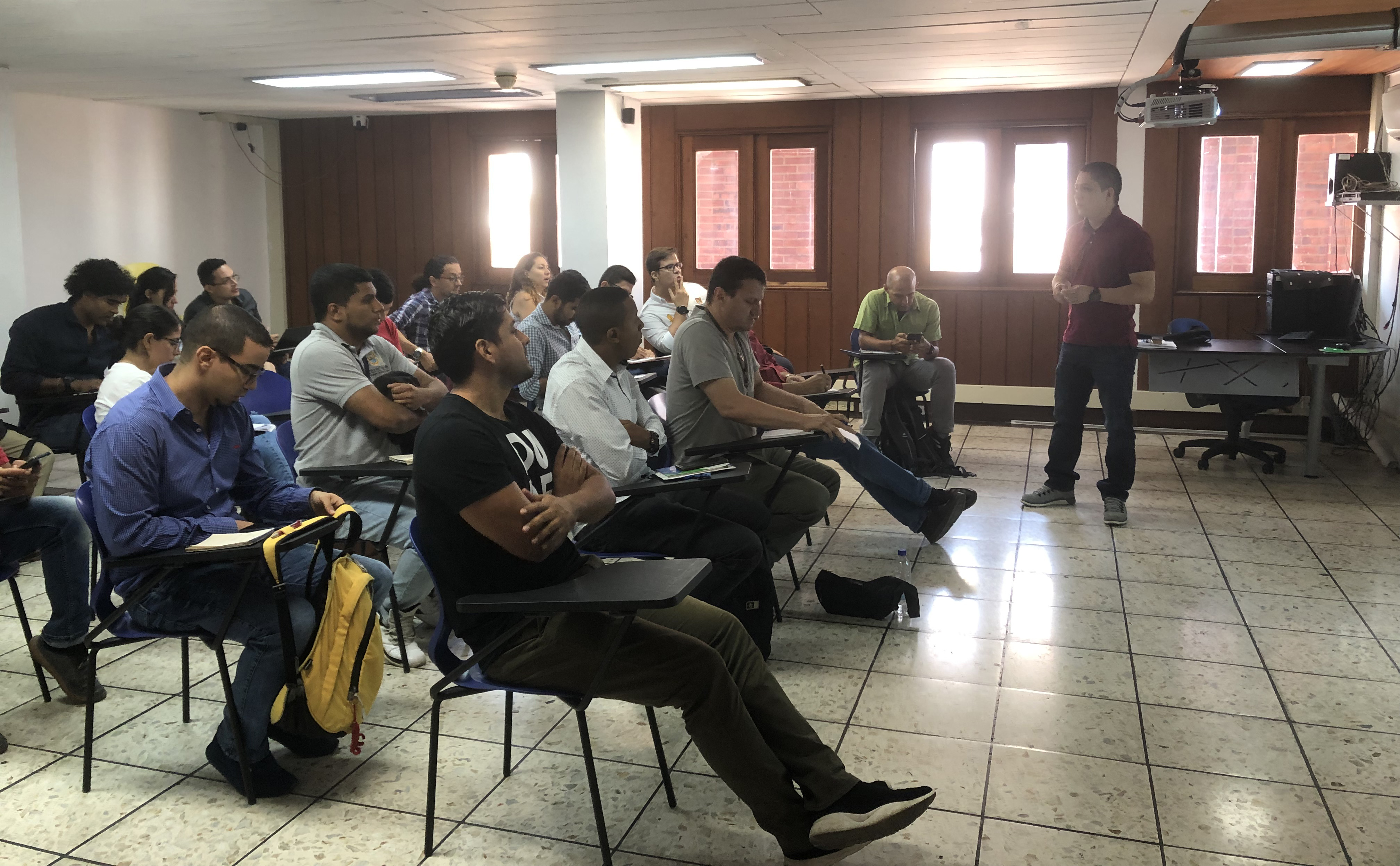 Fotografía de una jornada de socialización de la IDESC, en la cual los asistentes están prestando atención al expositor.