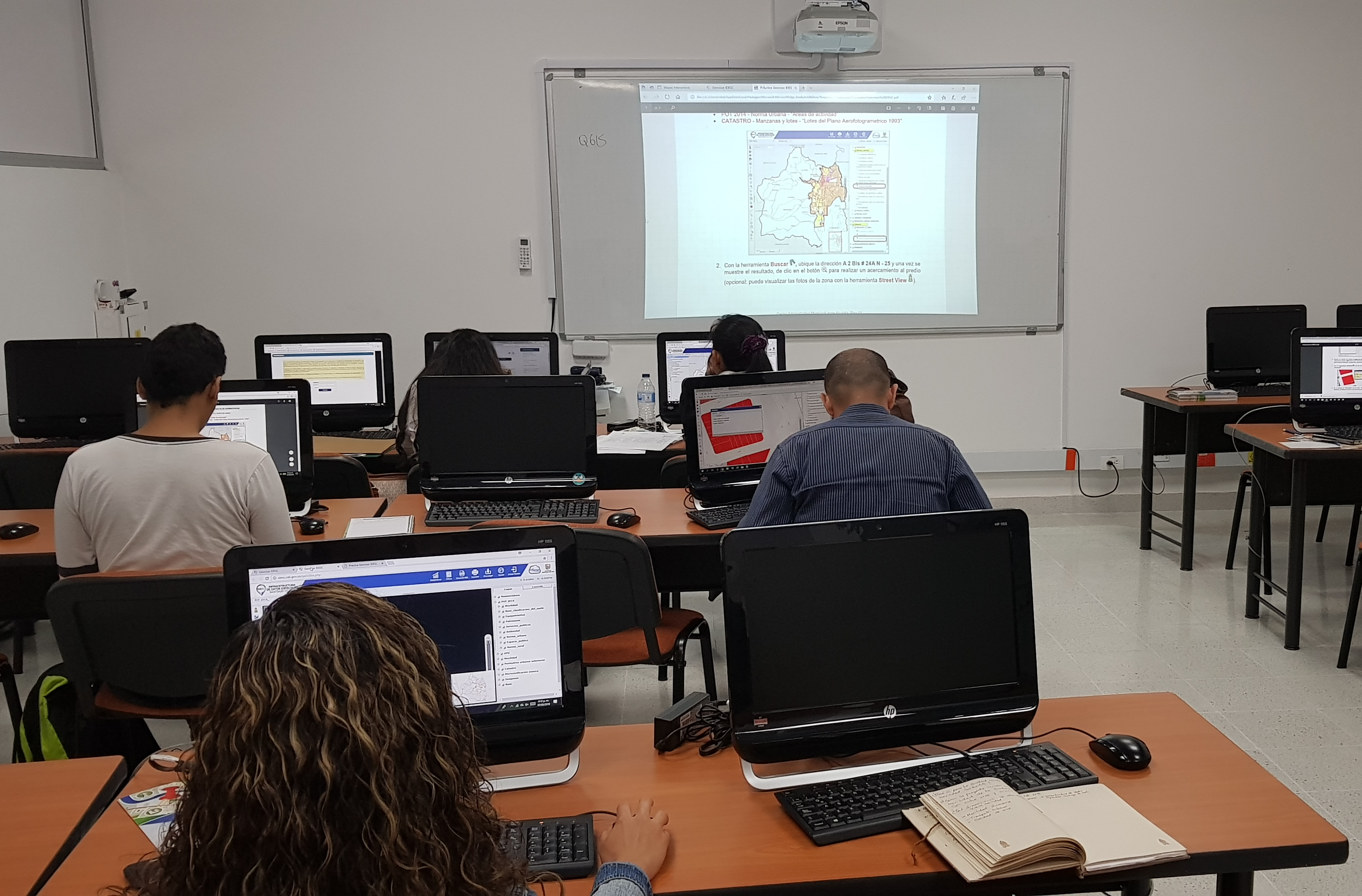 Personas en la sala de capacitaciones de la Escuela Nacional del Deporte sentadas frente a computadores realizando un taller práctico de los servicios de la IDESC.